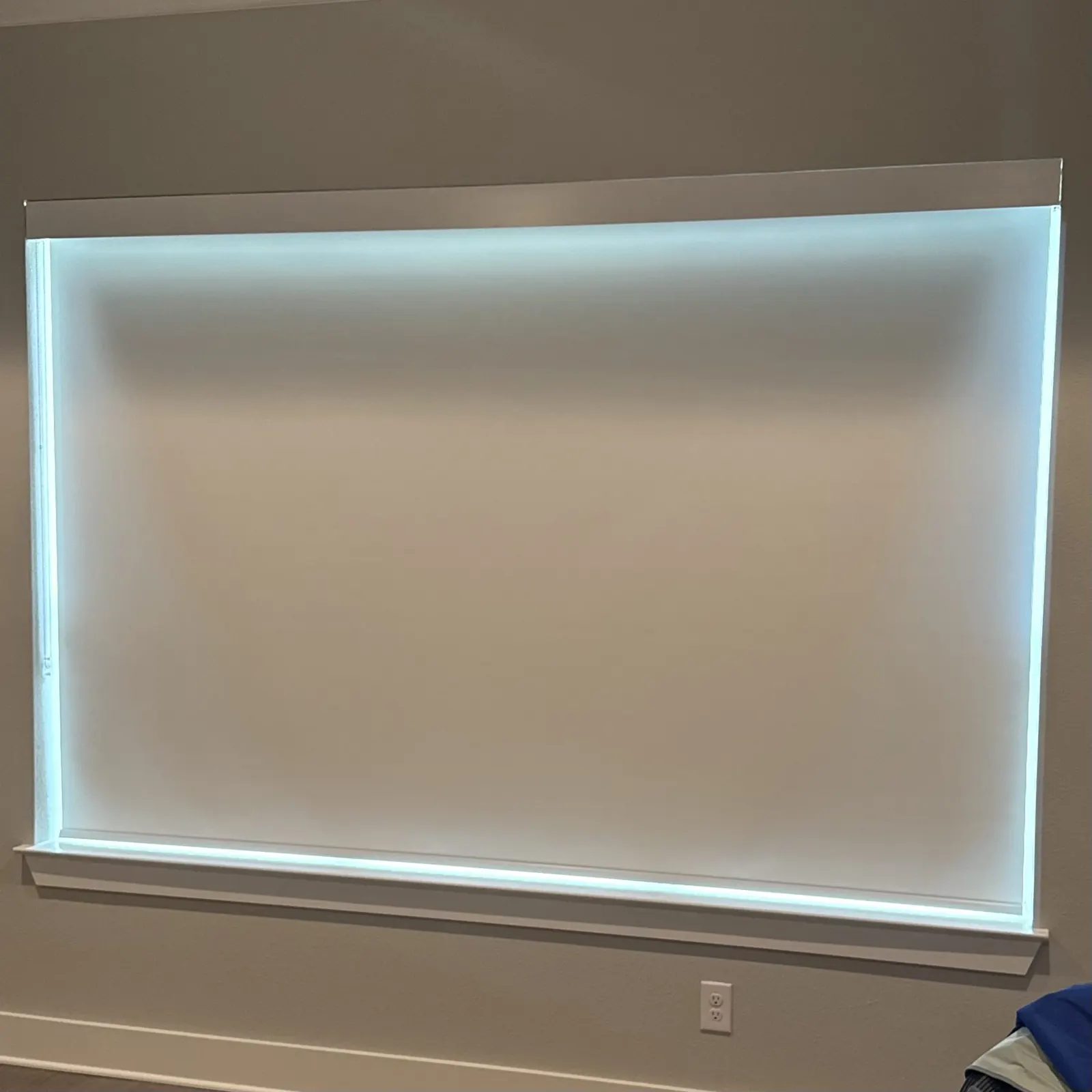 Wide inside-mounted blackout roller shade with daylight around the edges