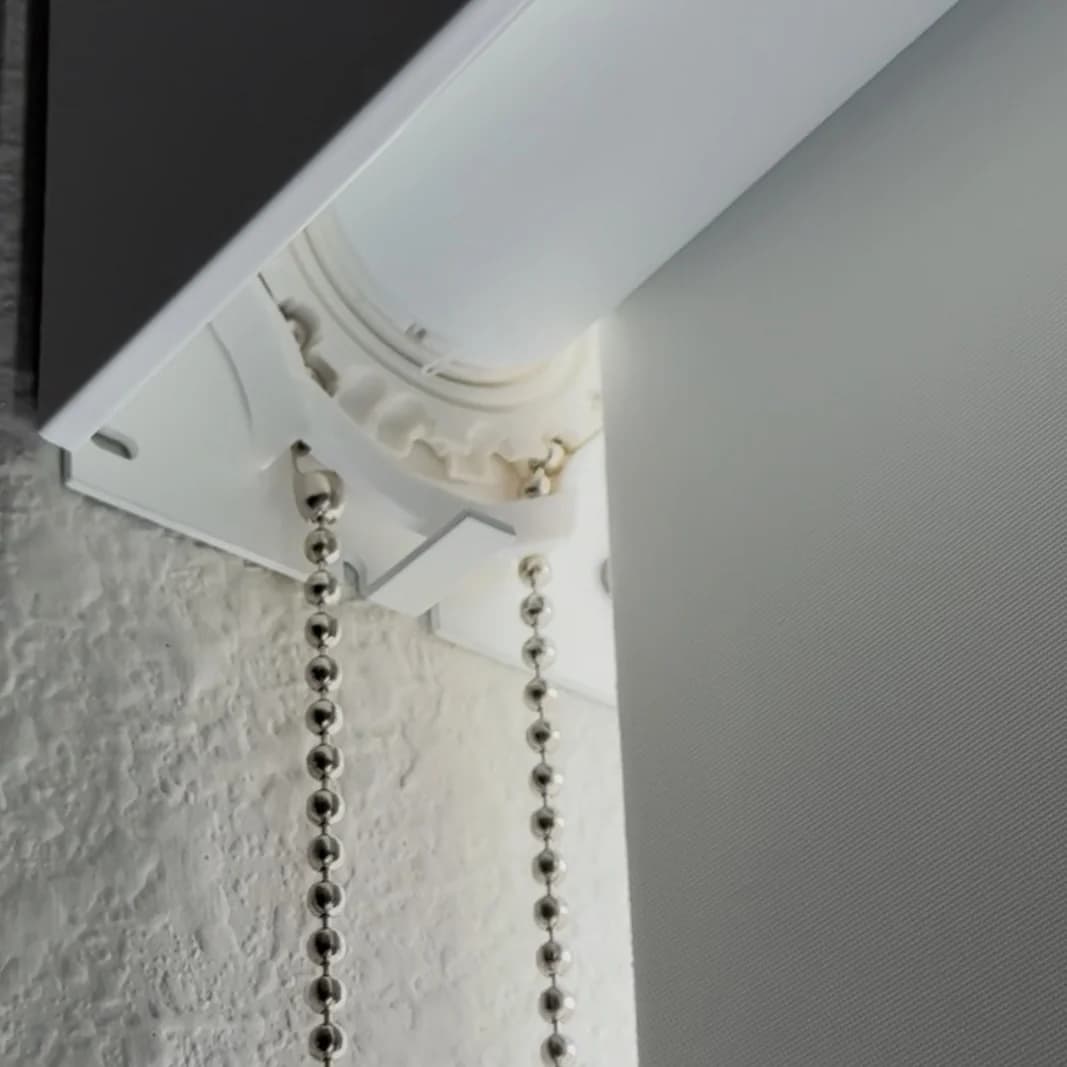 Close-up of a cordless blackout roller shade chain and cassette mount