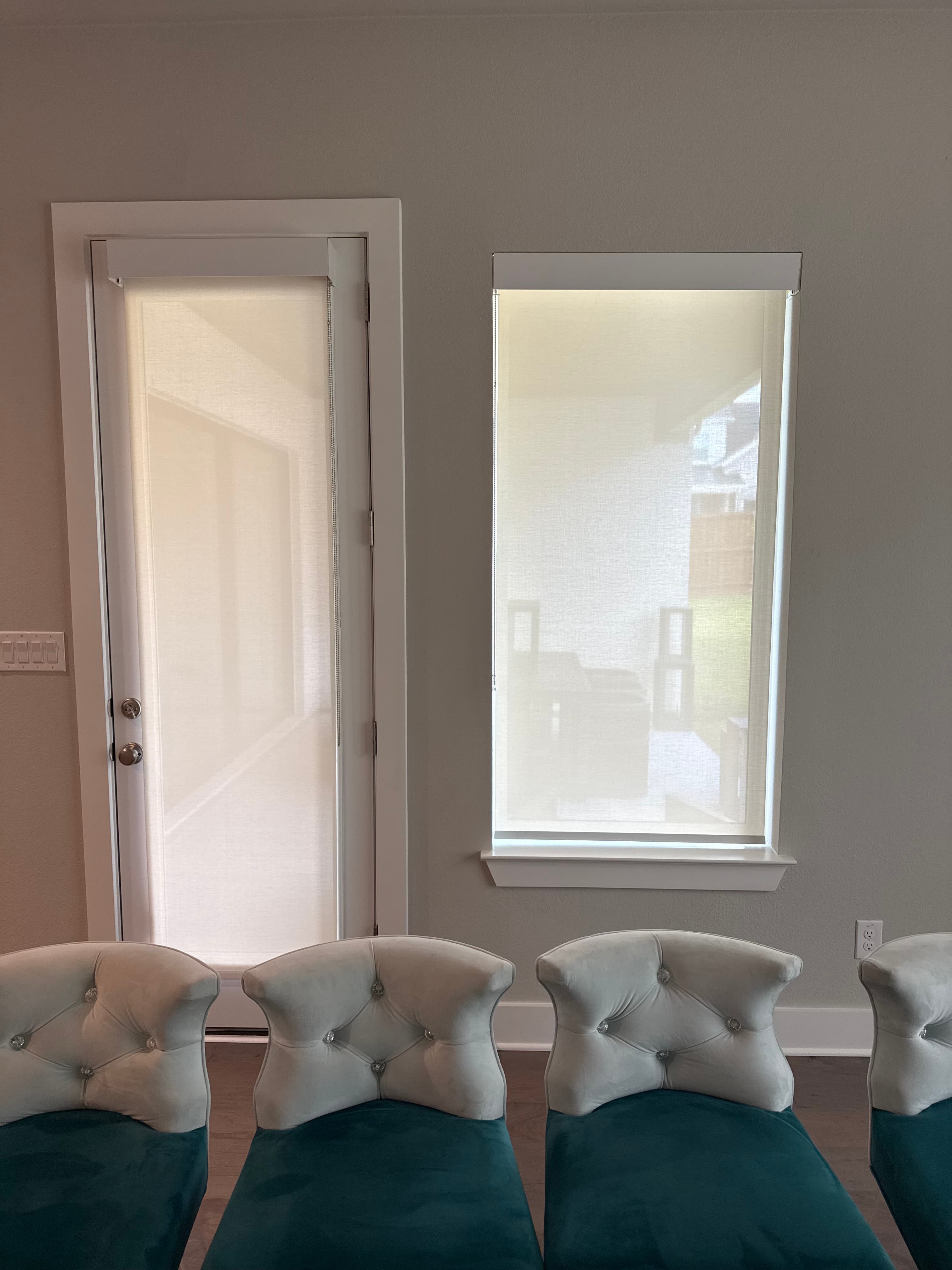 Green 3000 light-filtering roller shade on a patio door and blackout roller shade on a bedroom window in a new production home